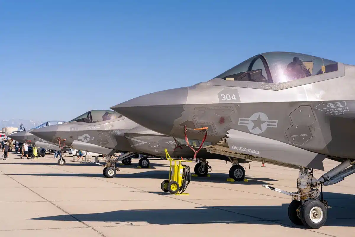 A stealth fighter silhouette against a sunset sky, tail-less design with advanced angles, emerging from shadow into golden light