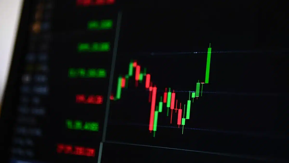 Stock market ticker displaying semiconductor stock symbols in green and red, candlestick charts climbing upward on a dark trading terminal screen | stock market performance display