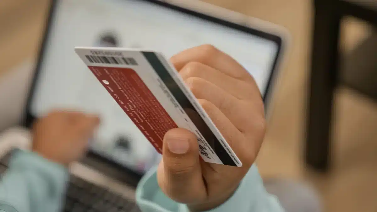 An older adult reviewing a bank statement or benefit notice on a computer screen, checking their Social Security payment arrival date and amount.