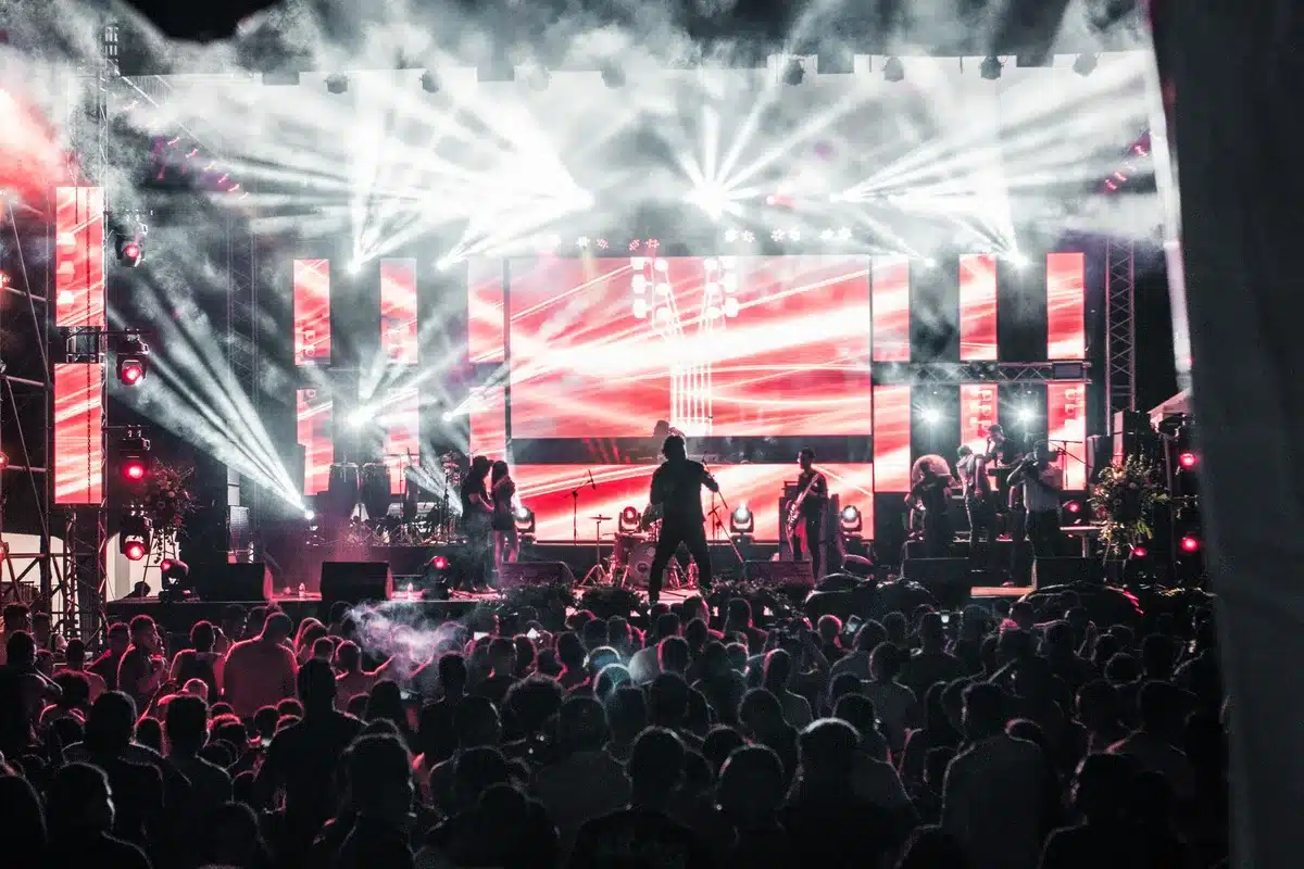 Empty stadium stage with single spotlight and microphone stand, dramatic lighting, anticipation atmosphere