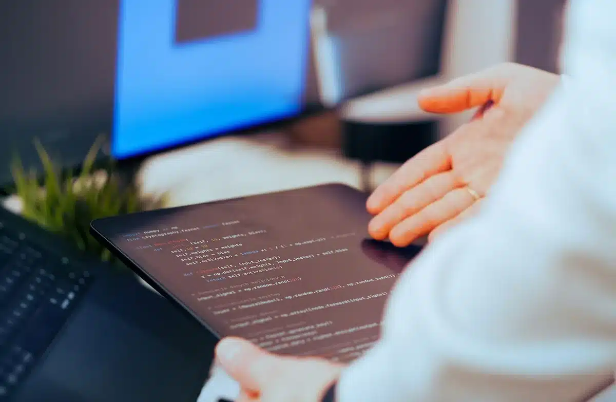 A modern office environment with team members collaborating around a conference table with laptops and charts visible, representing enterprise software deployment