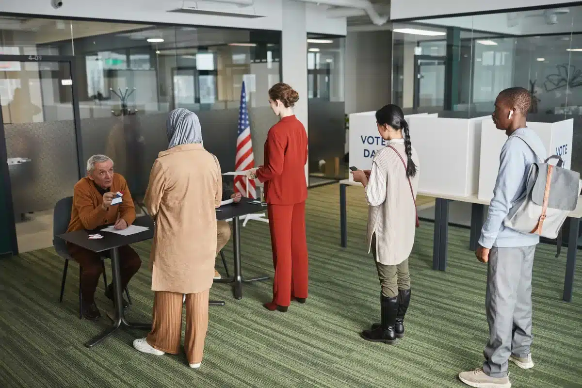 A voting booth interior with a South Carolina ballot on the table, morning light streaming through a window, an American flag visible in the background, voters waiting in a blurred line outside