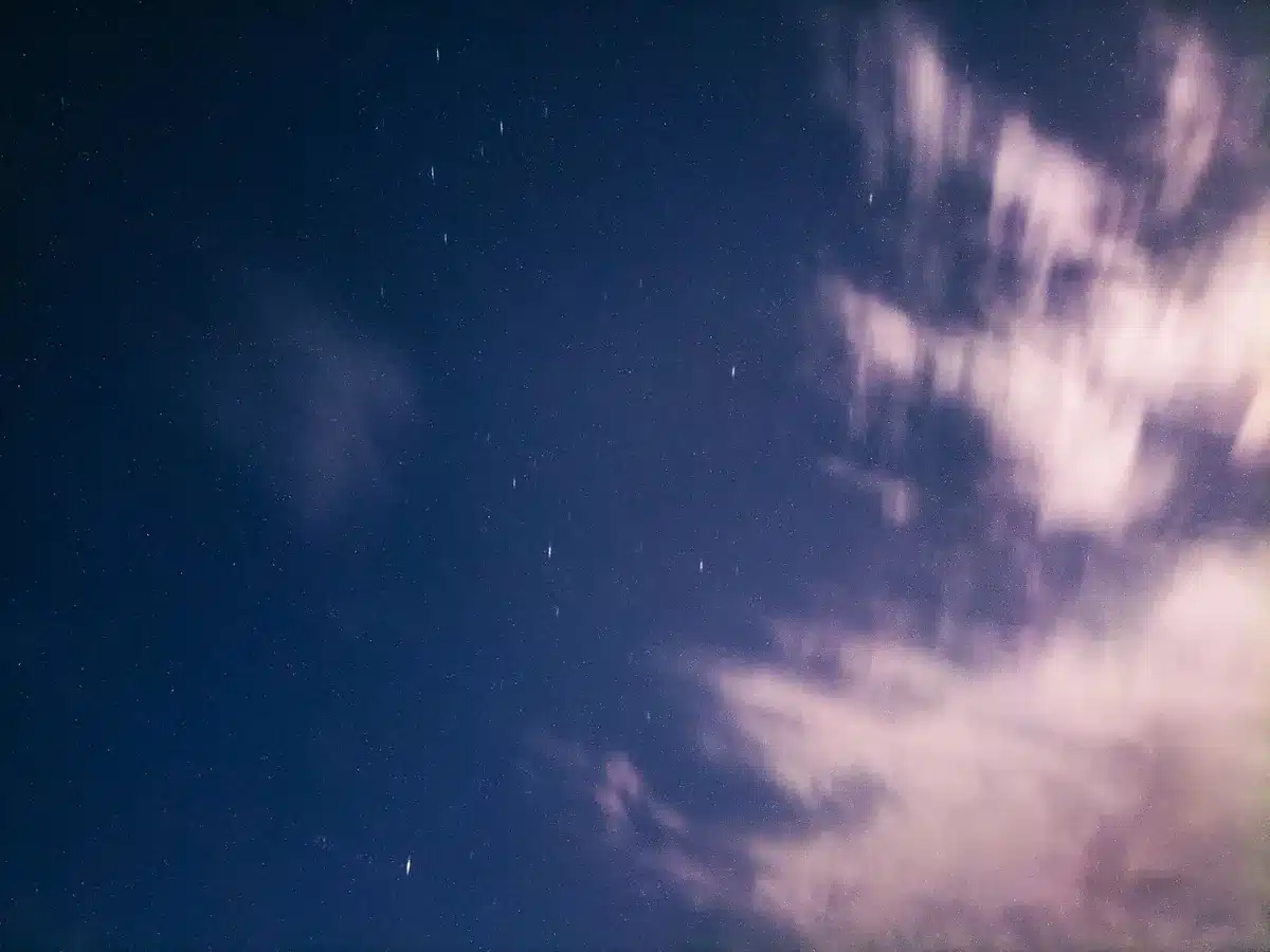 Satellite array against Earth's curve in space, with blue and white light reflecting off solar panels, showing interconnected network of communications infrastructure