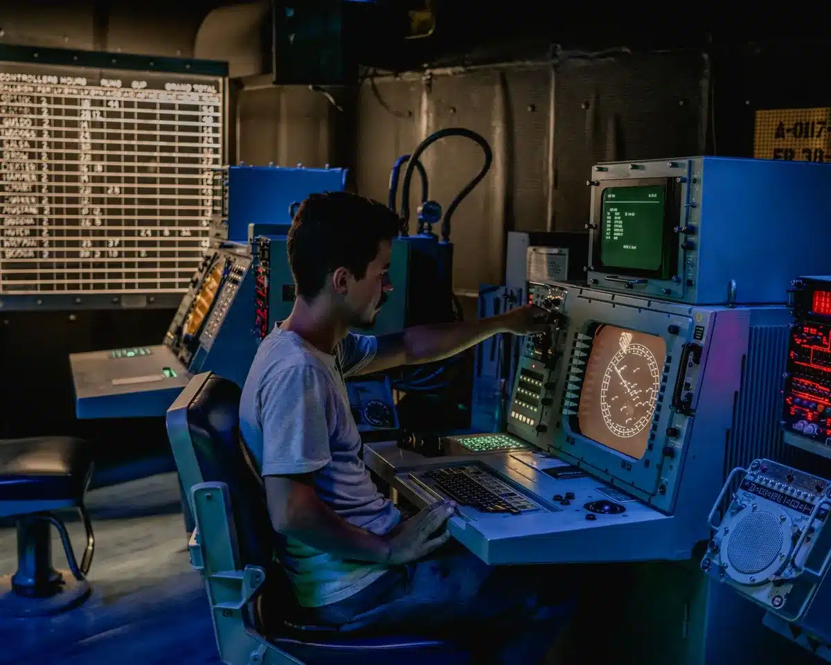 Mission control center with multiple screens displaying launch countdown data and telemetry, engineers in blue flight suits monitoring systems, focused expressions on faces.