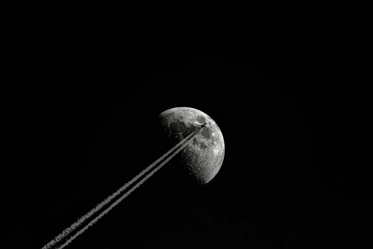 A spent rocket stage tumbling through space with the moon's gray, cratered surface visible below, solar panels catching sunlight, the moment before contact — anticipation.