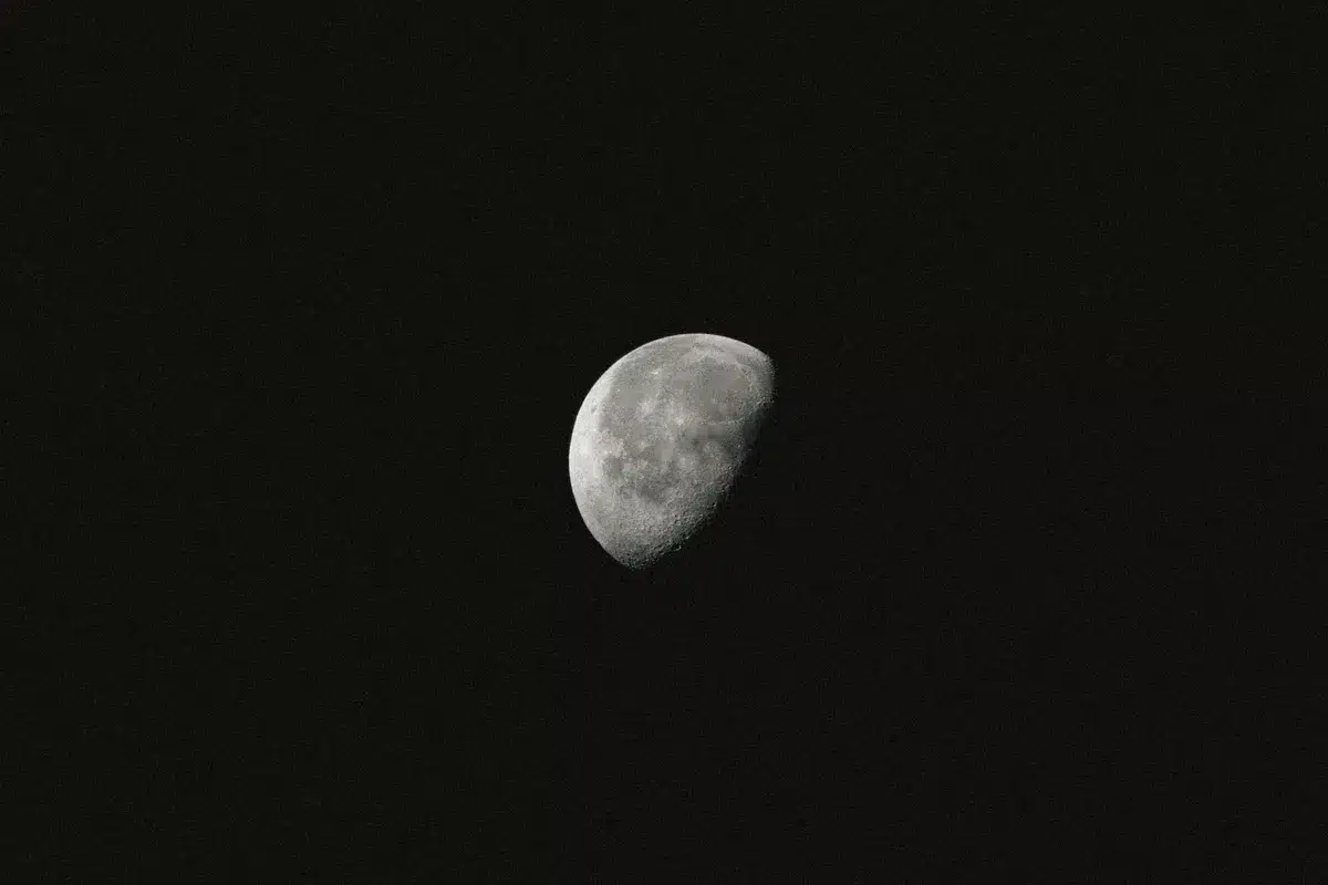 A split-screen view showing pristine lunar surface on one side and scattered debris and discarded equipment on the other, illustrating the contrast between untouched moon and human impact