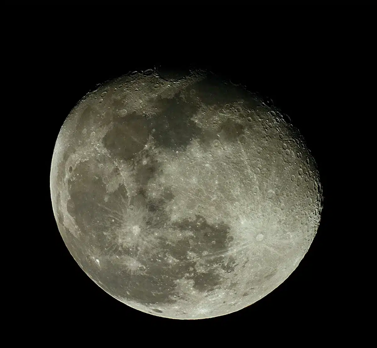 A lunar surface with a fresh impact crater surrounded by ejected debris and dust, near Einstein Crater, showing the bright rim and central disturbance zone