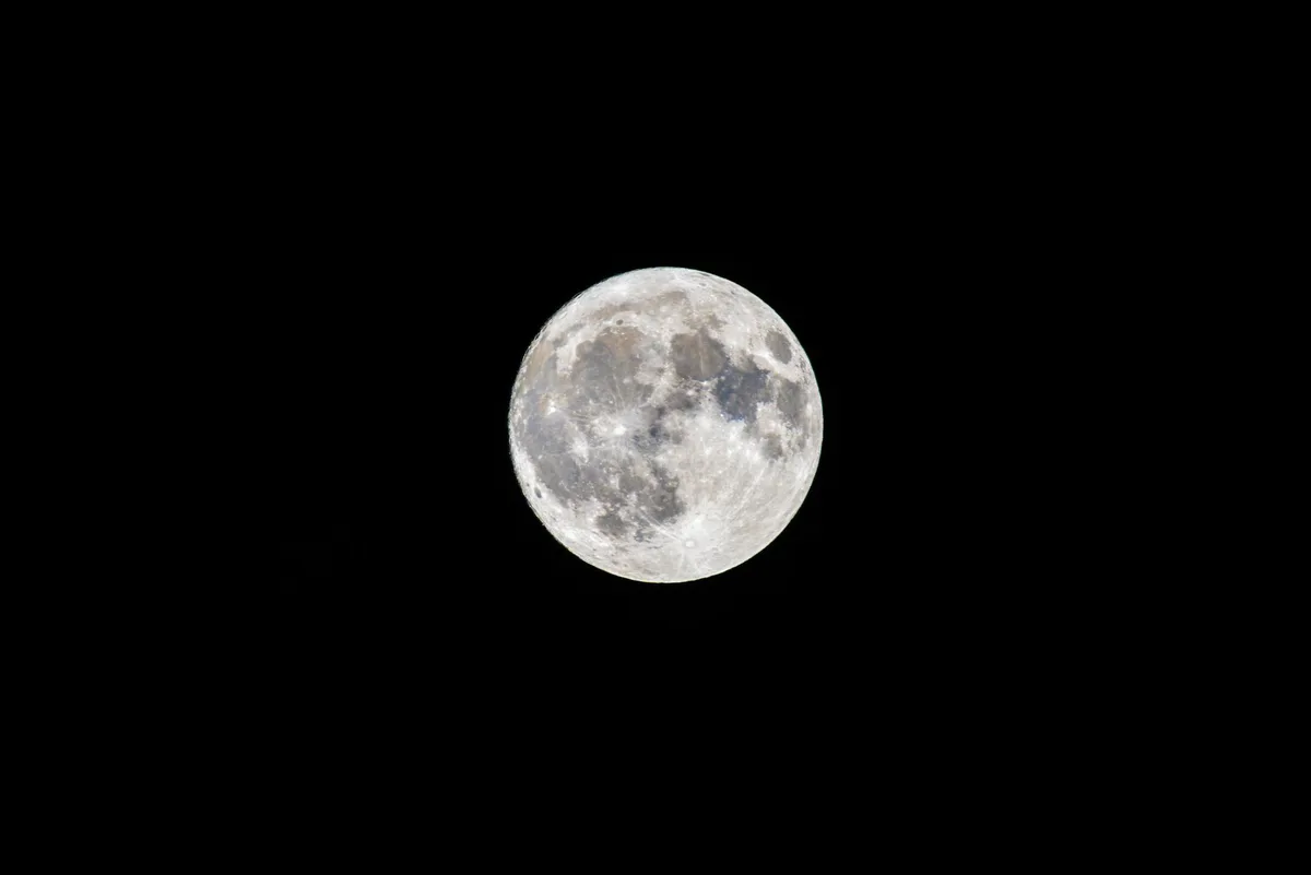 A spacecraft or orbiter observing the lunar surface from above, with instruments pointed downward toward the moon, representing scientific observation and data collection