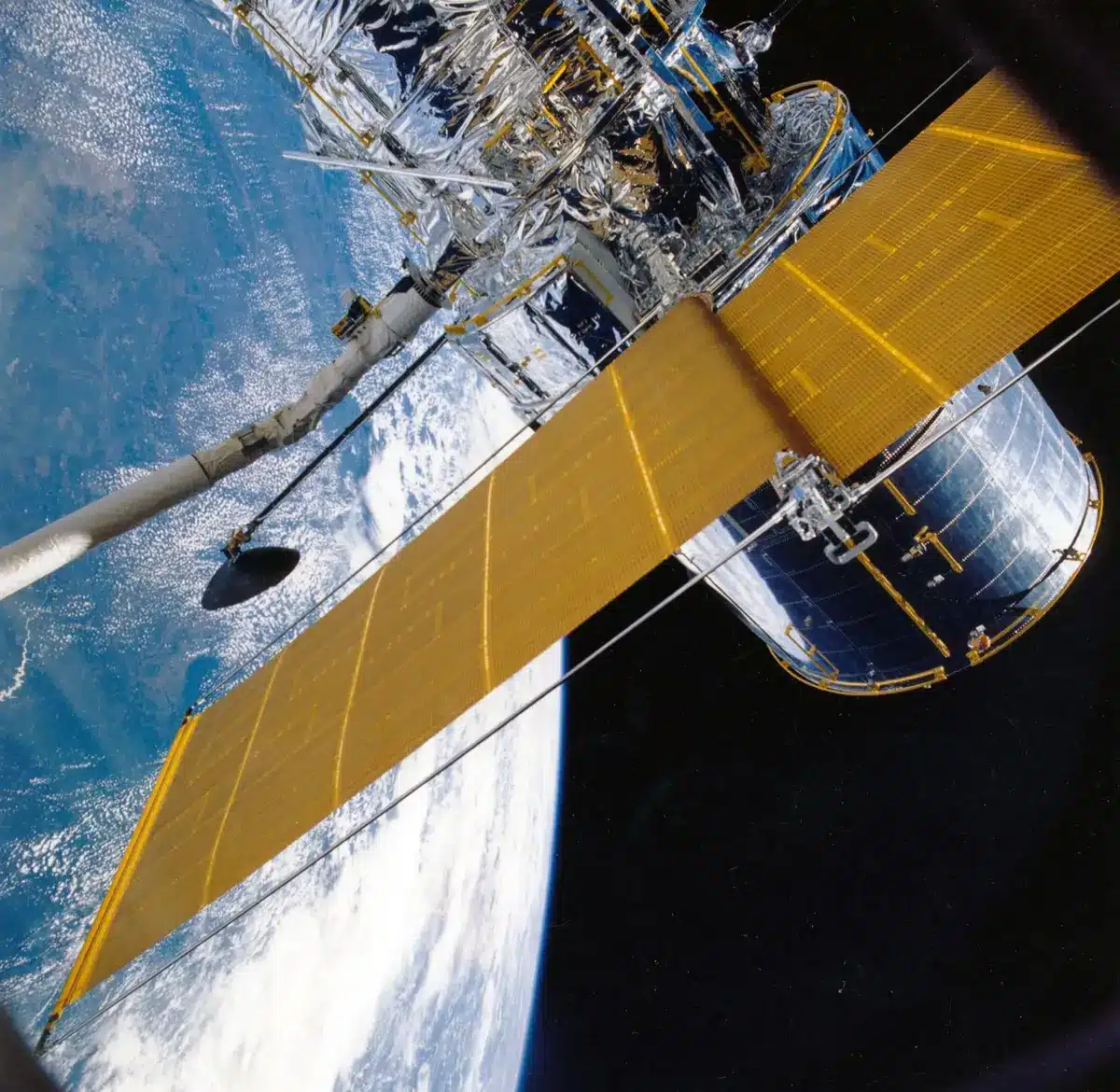 A satellite in the vacuum of space, solar panels extended, Earth's curved horizon below with city lights, the black void above scattered with distant stars