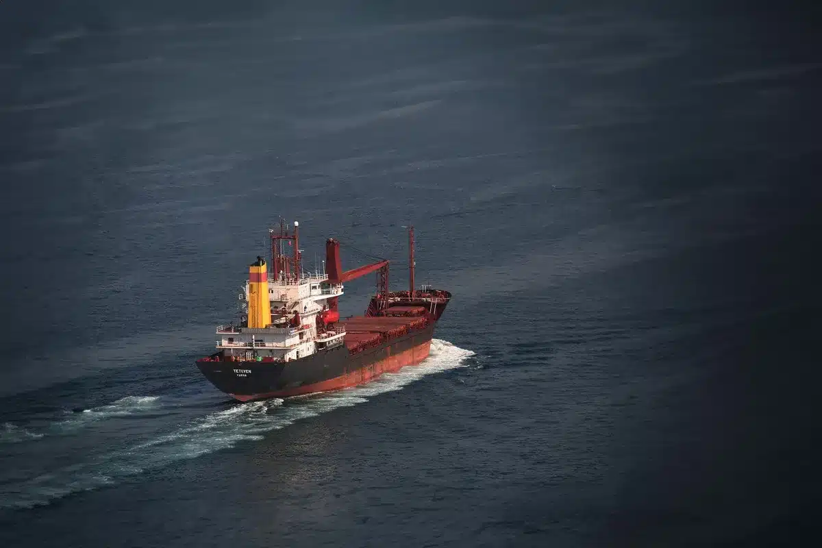 Multiple recovery vessels positioned around a large metallic spacecraft in open ocean, with satellite view showing their coordinated positioning and towing lines.