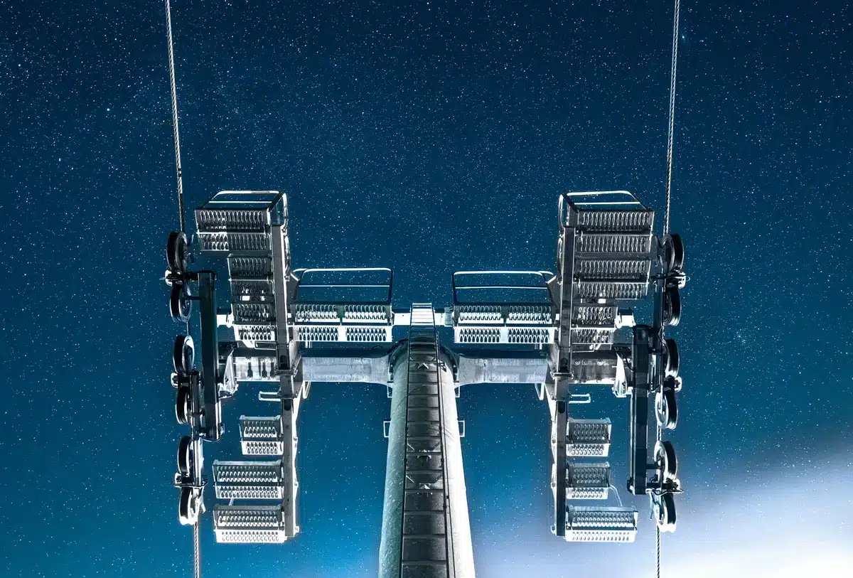 Mechanical "chopstick" arms of a launch tower at dusk, empty pad below, Texas landscape, industrial precision