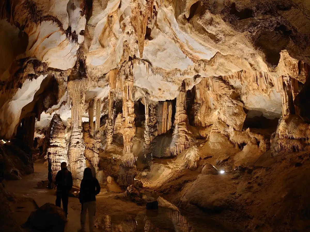 Cross-section diagram or conceptual view of salt dome caverns showing adjacent cavern chambers with thin salt pillars between them, one cavern partially depleted