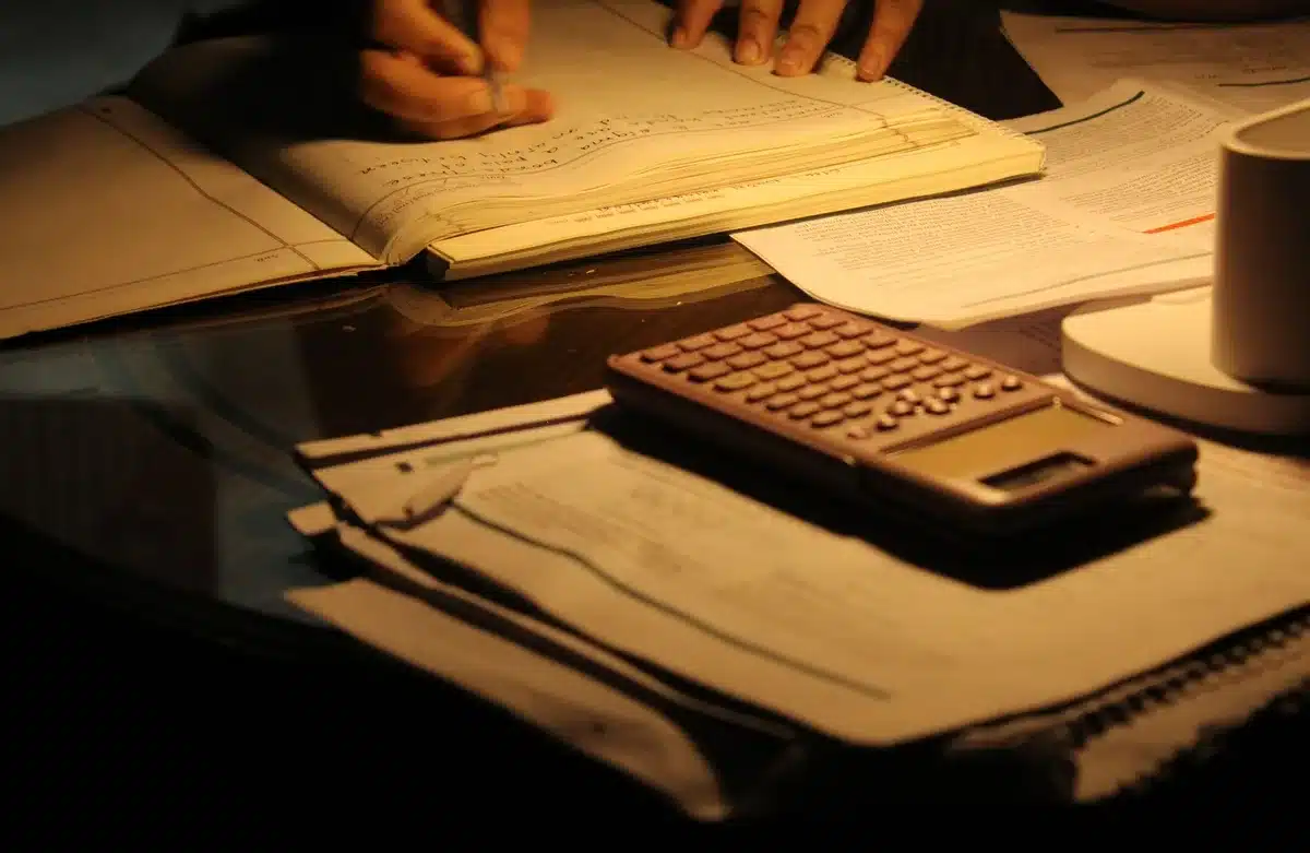 Stacks of student loan documents and paperwork scattered on a desk, with a gavel resting nearby, harsh overhead lighting casting sharp shadows on the papers, representing legal accountability