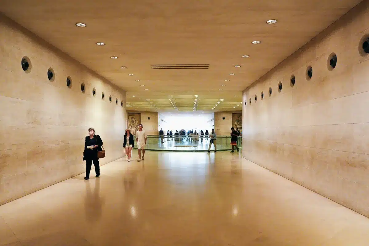 Capitol building interior hallway with senators walking in conversation, fluorescent lights casting shadows, papers scattered on a nearby table, tension visible in body language