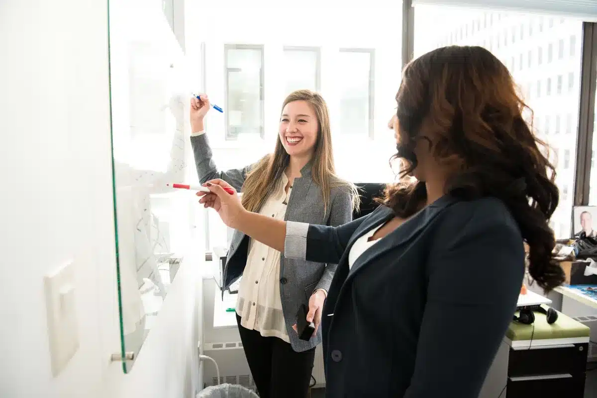 An executive at a modern tech campus, standing before sleek architectural glass and steel, professional attire, confident posture, soft natural light, symbolizing corporate leadership transition and continuity.