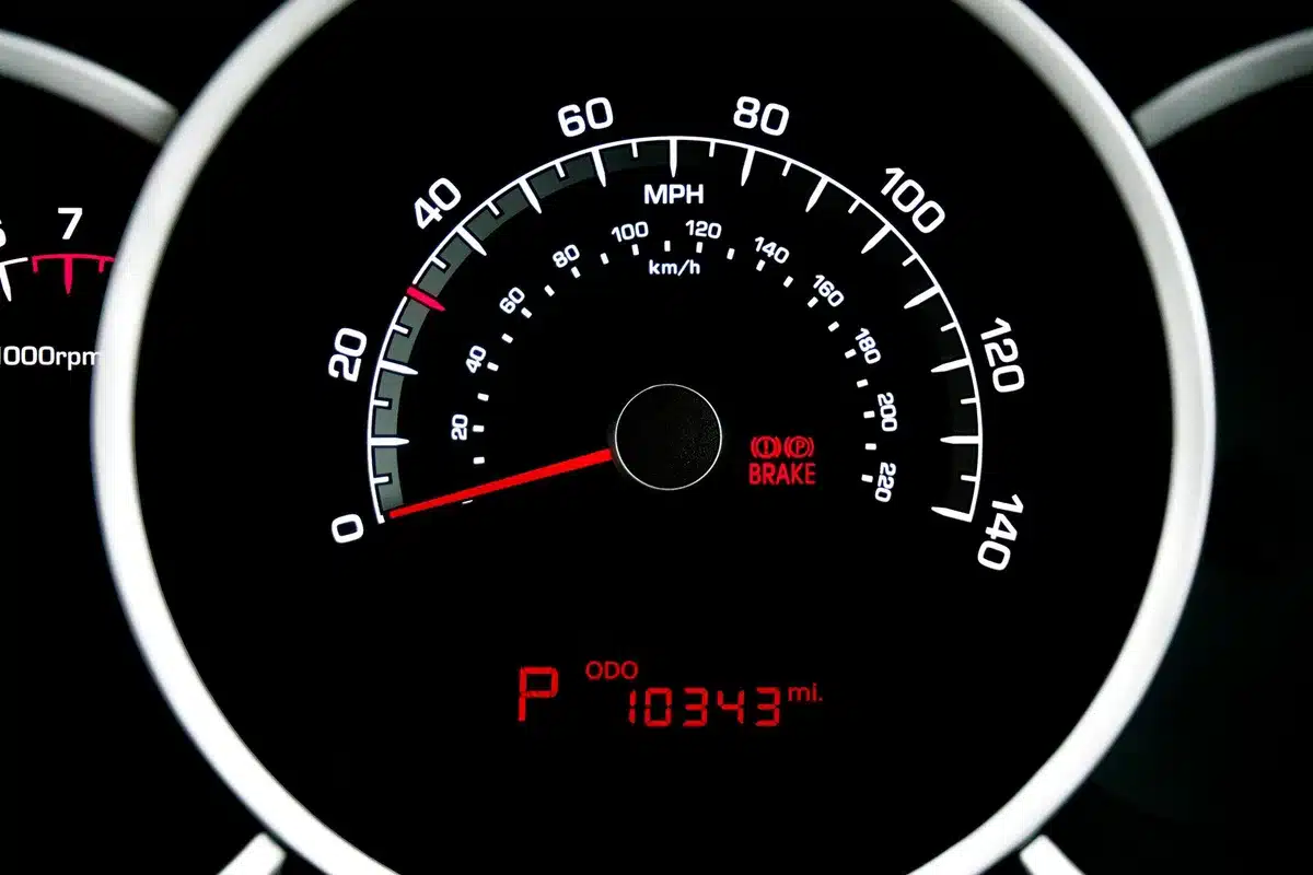 A digital dashboard display showing warning lights and gauges, modern car interior with blank screen area, minimal lighting