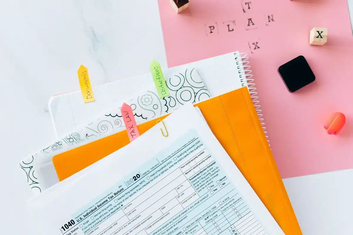 Stacked legal documents and financial folders in a dimly lit office, papers slightly askew and scattered, a magnifying glass resting on one document, filing cabinets in soft focus behind, suggesting discovery and investigation