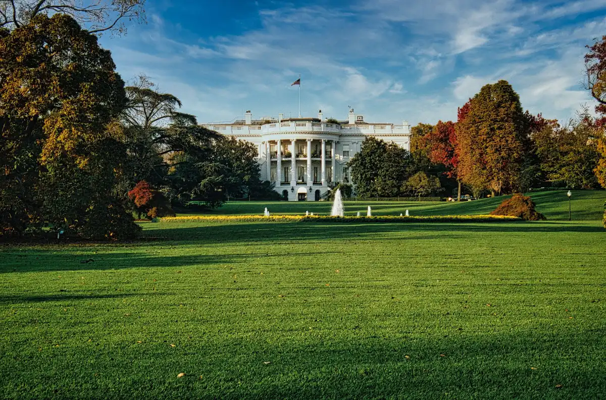 A formal White House office with an empty leather chair behind a polished desk, papers organized in neat stacks, suggesting the handoff of a high-level position.