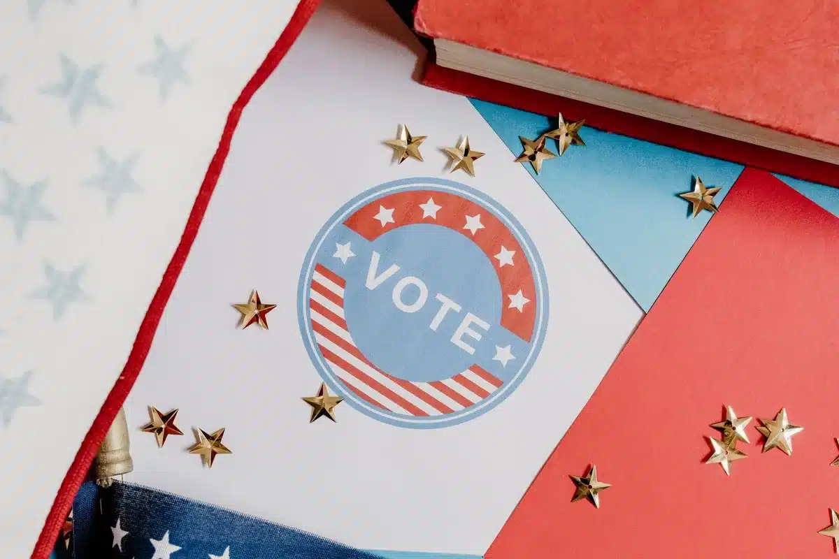 Primary election night coverage scene with news anchors and graphics, polling maps and vote totals displayed, neutral news studio setting