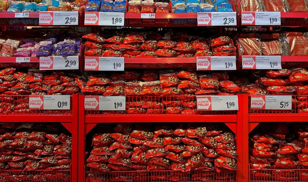 A grocery store shelf displaying packages of ground beef at various price points, with price tags visible, showing the retail cost of meat in an average American supermarket setting.
