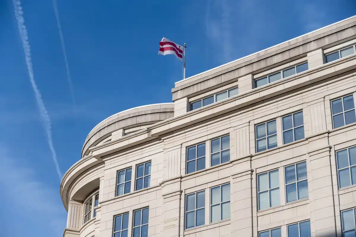 FDA headquarters building exterior in daylight, American flag prominent, institutional architecture, empty entrance plaza