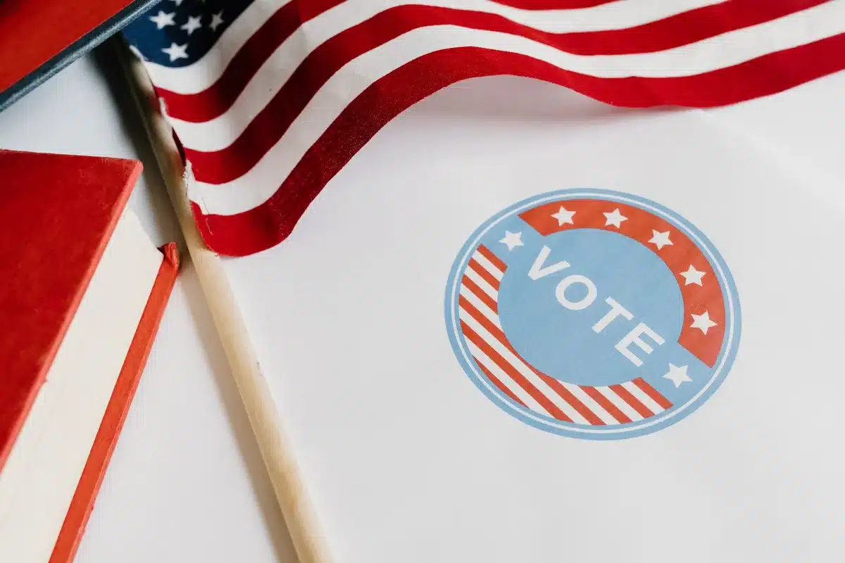 A close-up of a politician's campaign materials and endorsement pins scattered on a desk, symbolizing the mechanics of political backing and its limits.