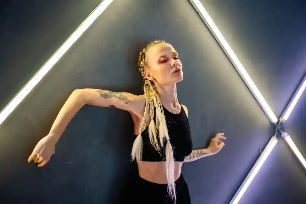 Close-up of blonde hair under bright stage lighting, showing texture and volume, shallow depth of field, professional styling visible