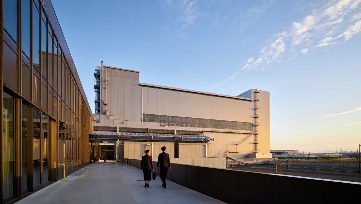 Industrial semiconductor fabrication facility exterior with Japanese architectural elements, modern glass and steel construction, morning light | semiconductor factory Japan