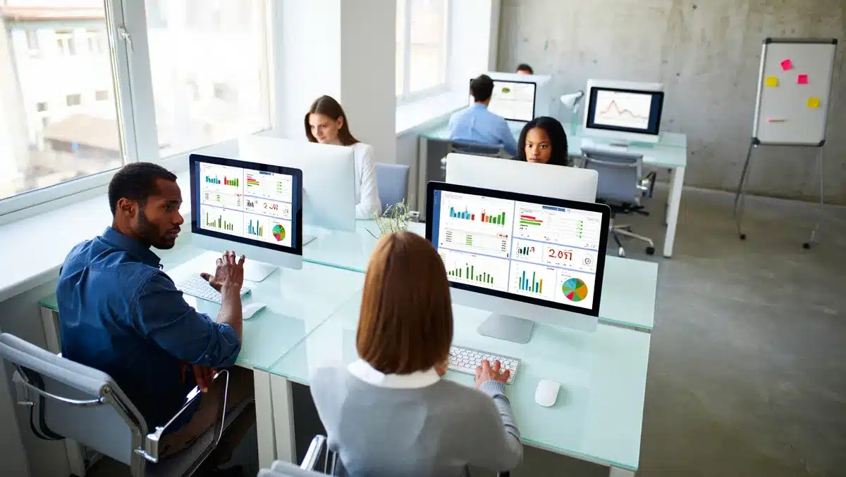 A corporate office with data analysts reviewing analytics dashboards on multiple screens, visualizing audience metrics and traffic patterns | audience data analytics office