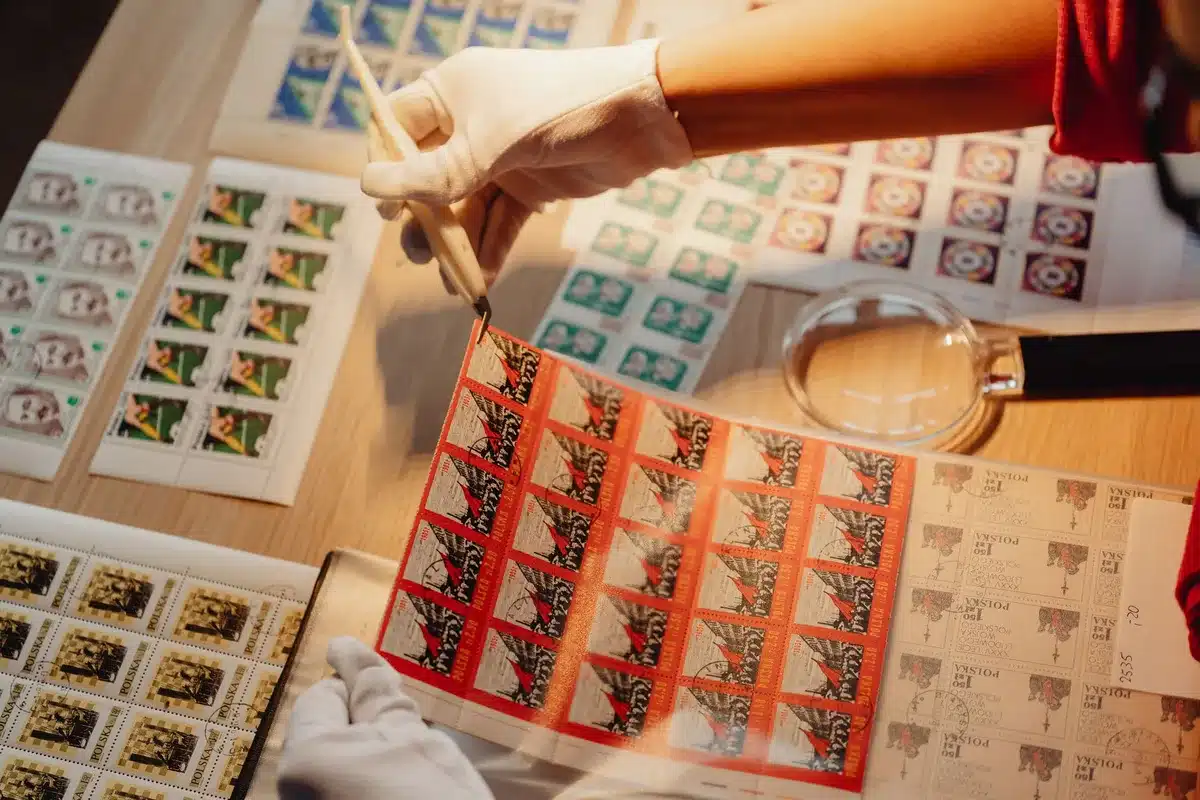 A postal worker sorting mail in a distribution facility, handling envelopes with official markings, focused on mail processing and ballot handling logistics.