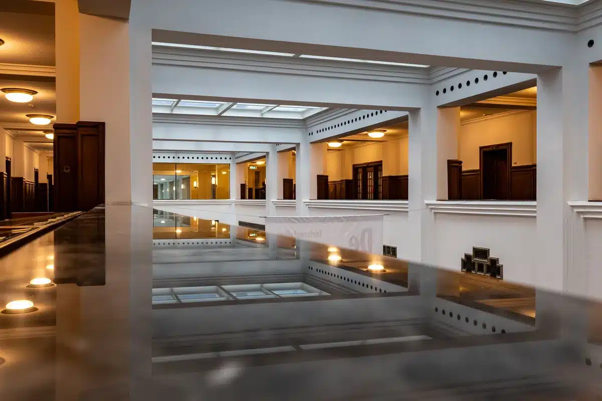 An empty post office interior with closed service windows and a dim, quiet atmosphere, conveying the challenge of maintaining unprofitable locations nationwide.