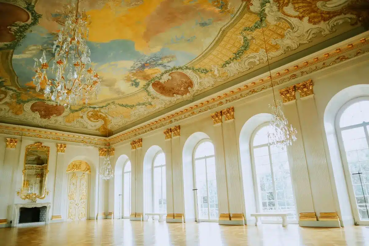 An interior architectural rendering or blueprint showing a large formal ballroom space with ornate details, high ceilings, and elegant finishes, rendered in neutral tones with clean lines and refined proportions