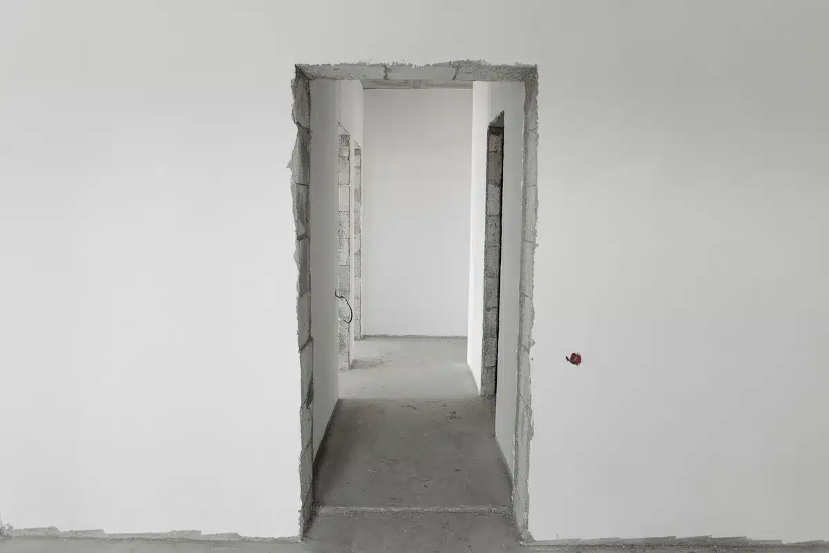 Empty White House corridor with architectural details visible, dim lighting suggesting administrative pause, no people visible.