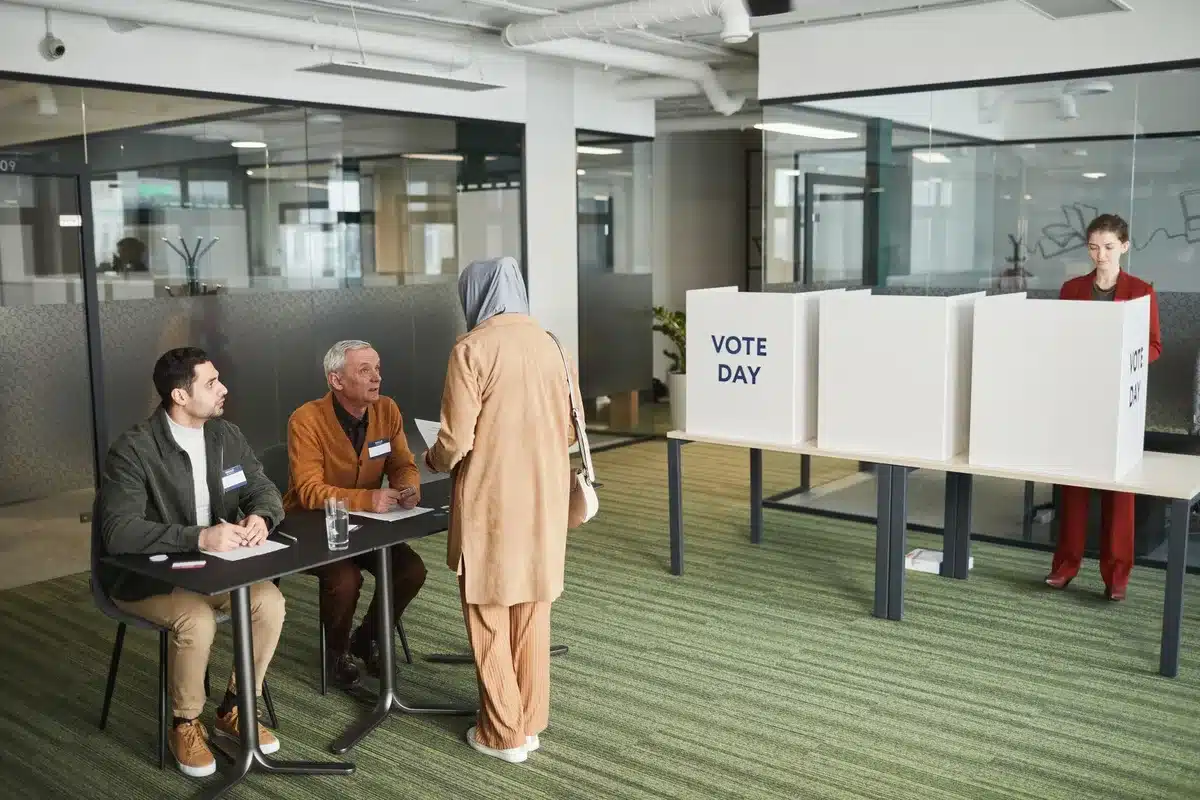 A diverse group of anonymous voters in a polling place, some holding completed ballots, others studying candidate information cards at a voting booth, soft indoor lighting casting shadows on voting materials