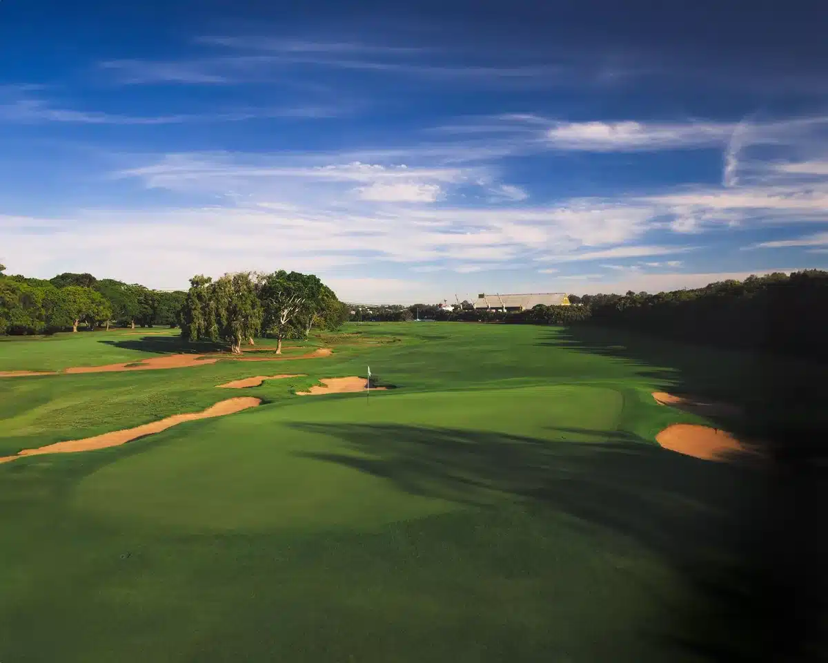 Golf course fairway stretching into distance under blue sky, manicured greens and rough visible, championship-quality condition, Sedgefield's signature layout
