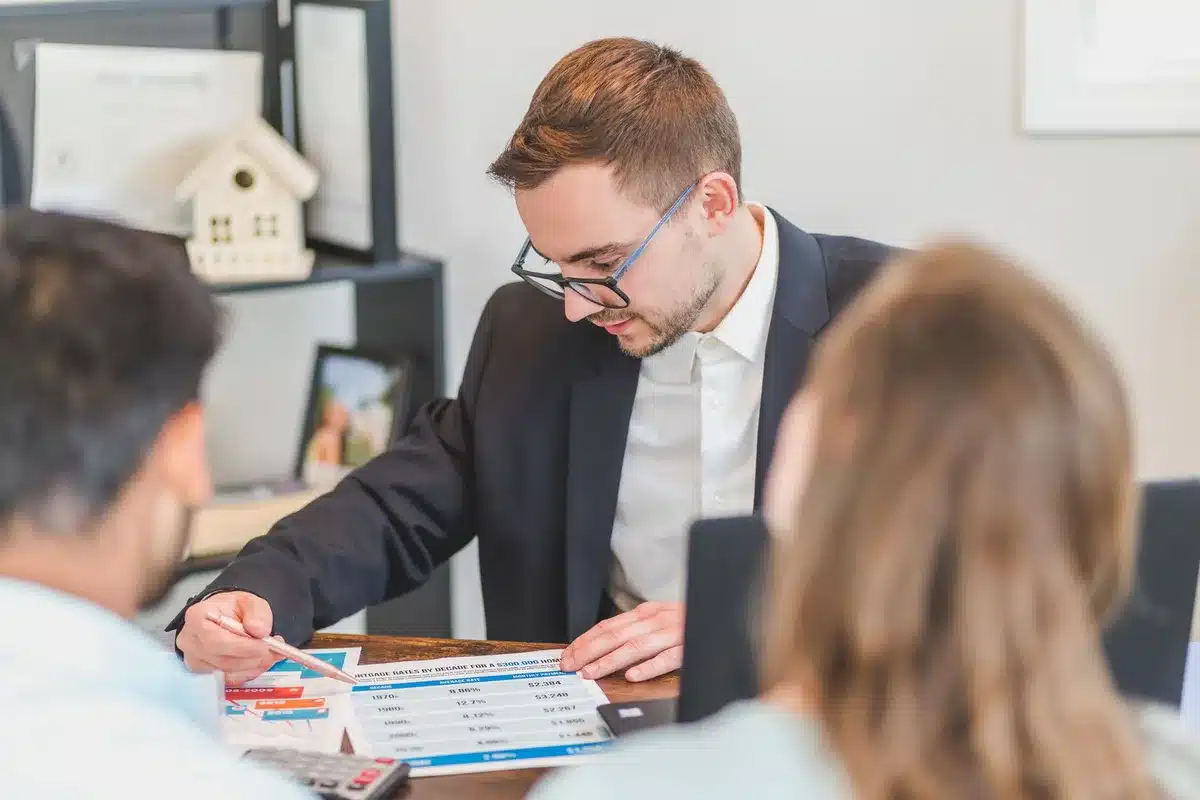 anonymous hands holding mortgage paperwork and a calculator on a desk, paper edges visible but no logos or personal identifiers