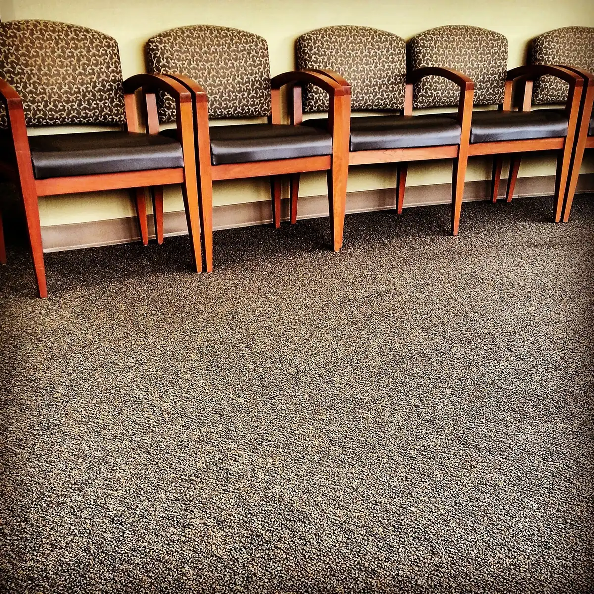 Empty corporate workspace with scattered chairs and an unbranded stack of cardboard boxes by a window, no people visible