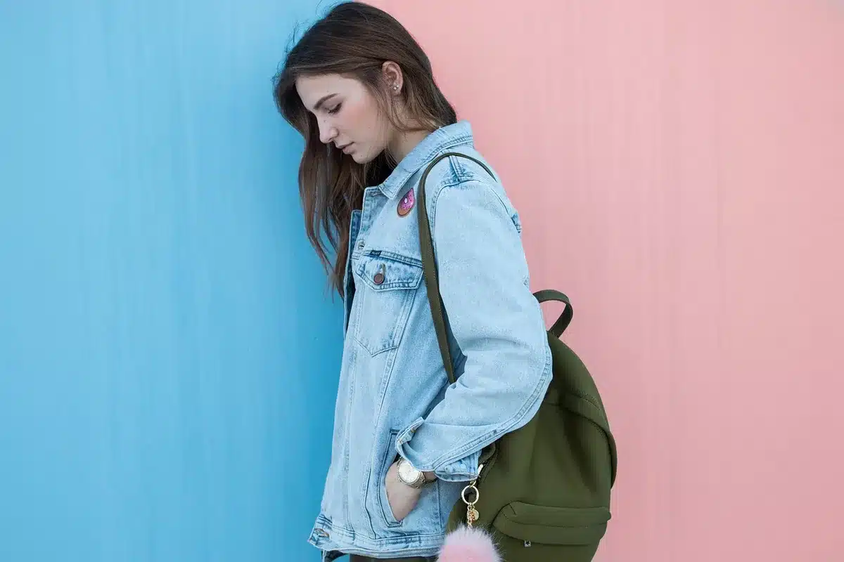 A young athlete in casual oversized streetwear sitting in a modern studio setting, relaxed confident posture, natural lighting highlighting fabric textures