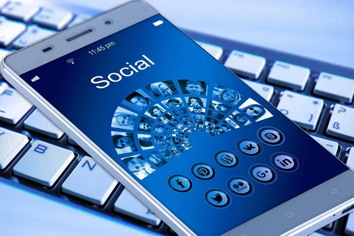 close-up of an anonymous hand opening an unbranded folding phone to reveal a large inner display, soft stage lighting