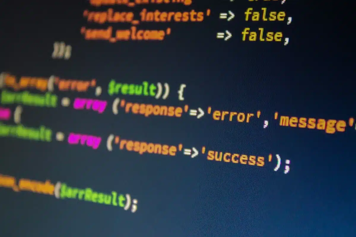 An anonymous silhouette of a person looking at a bank of monitors displaying abstract code and charts, face turned away and unidentifiable