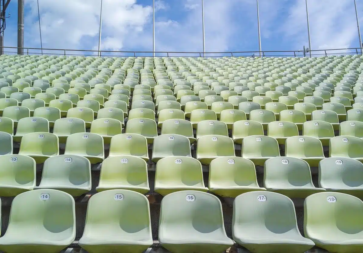 empty winner's podium under stadium lights, single spotlight on a lone chair, quiet aftermath of a game