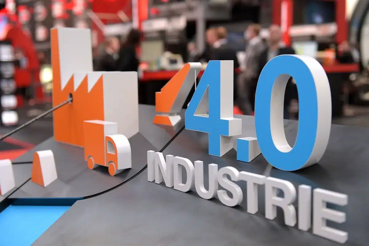A commercial aircraft under bright overhead lighting in a manufacturing facility, fuselage sections positioned on assembly line equipment, industrial workspace with precision tools and workbenches visible, capturing the scale of aerospace production