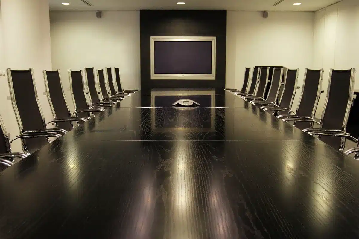 A corporate office interior with glass walls and modern furniture, suggesting a business environment where sponsorship negotiations might occur, no people visible.
