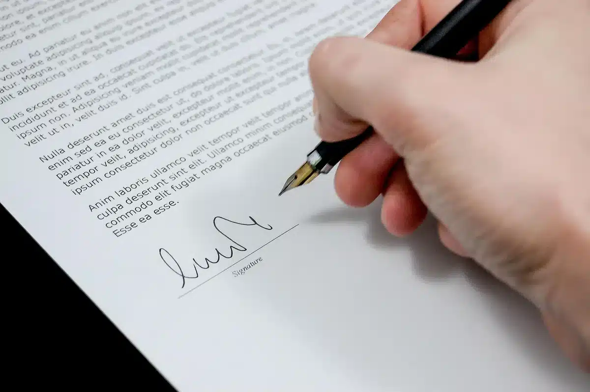 A generic healthcare policy binder and printed rate tables on a conference table, an anonymous hand pointing at a highlighted line item, no logos or identifiable people