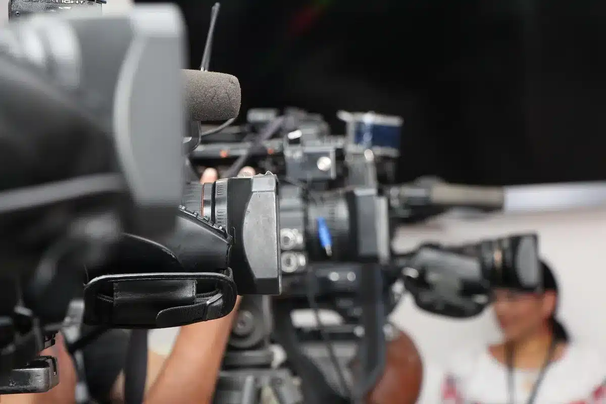 An empty press riser and a lone microphone on a plain lectern in a bright, empty press room, no people or logos visible, a folded press credential left on the table hinting at denied access