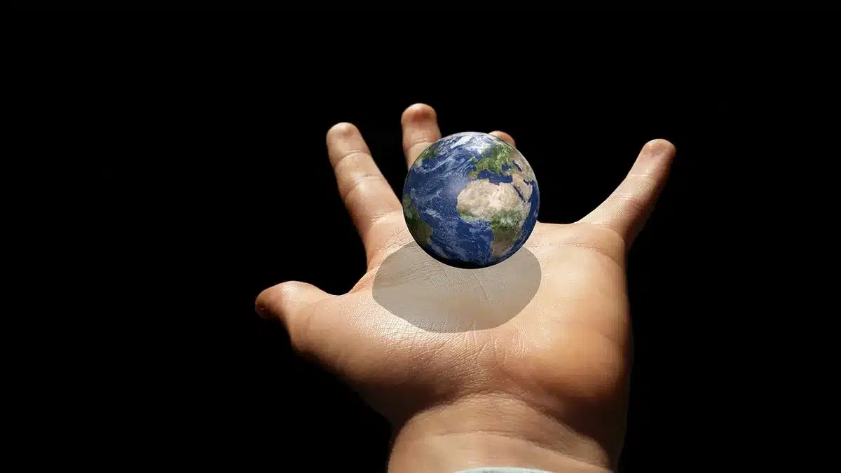 Close-up of a personless classroom globe stand showing latitudinal lines and a reduced Europe silhouette under soft light