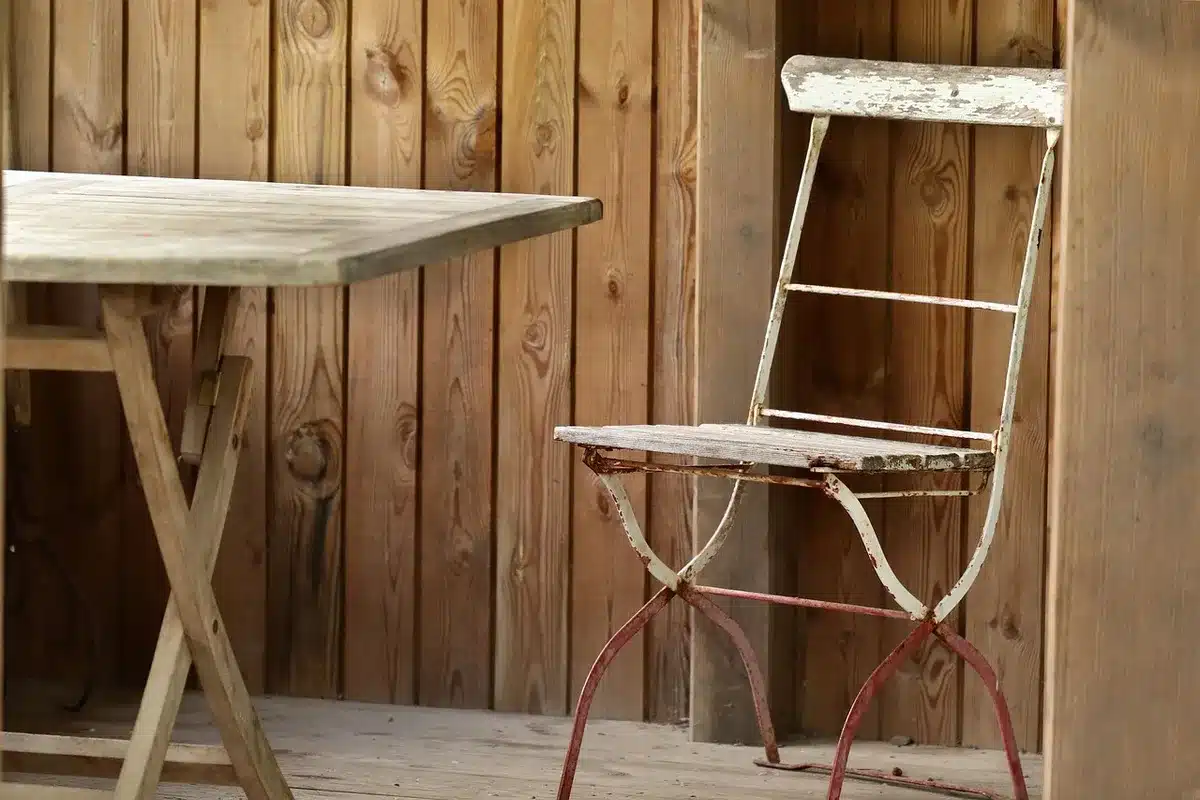 Close-up of an empty witness chair and a placard reading 'WITNESS' on a wooden table, with hearing papers stacked nearby; microphones sit ready but unattended