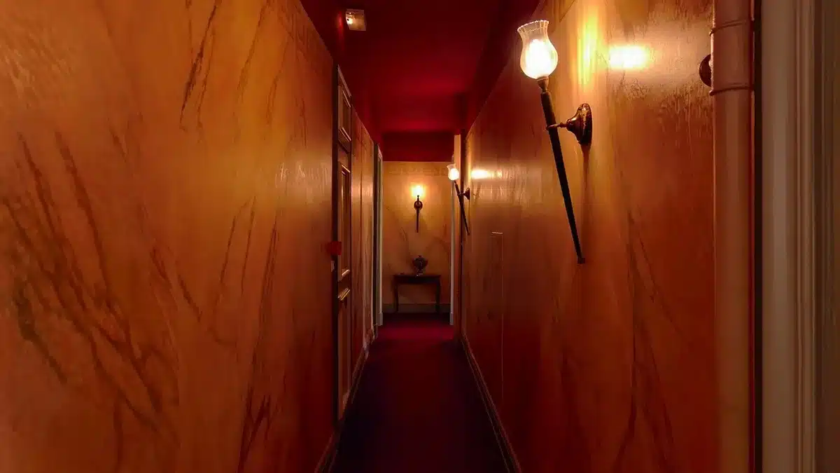 A dimly lit Senate office hallway with empty chairs and closed doors, soft fluorescent light casting long shadows on polished marble floors, a single nameplate visible on an office entrance, conveying institutional absence and disengagement