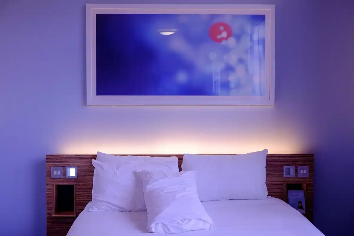 A quiet hotel ballroom with a small stage and a projection screen, set with water glasses and notepads for panelists