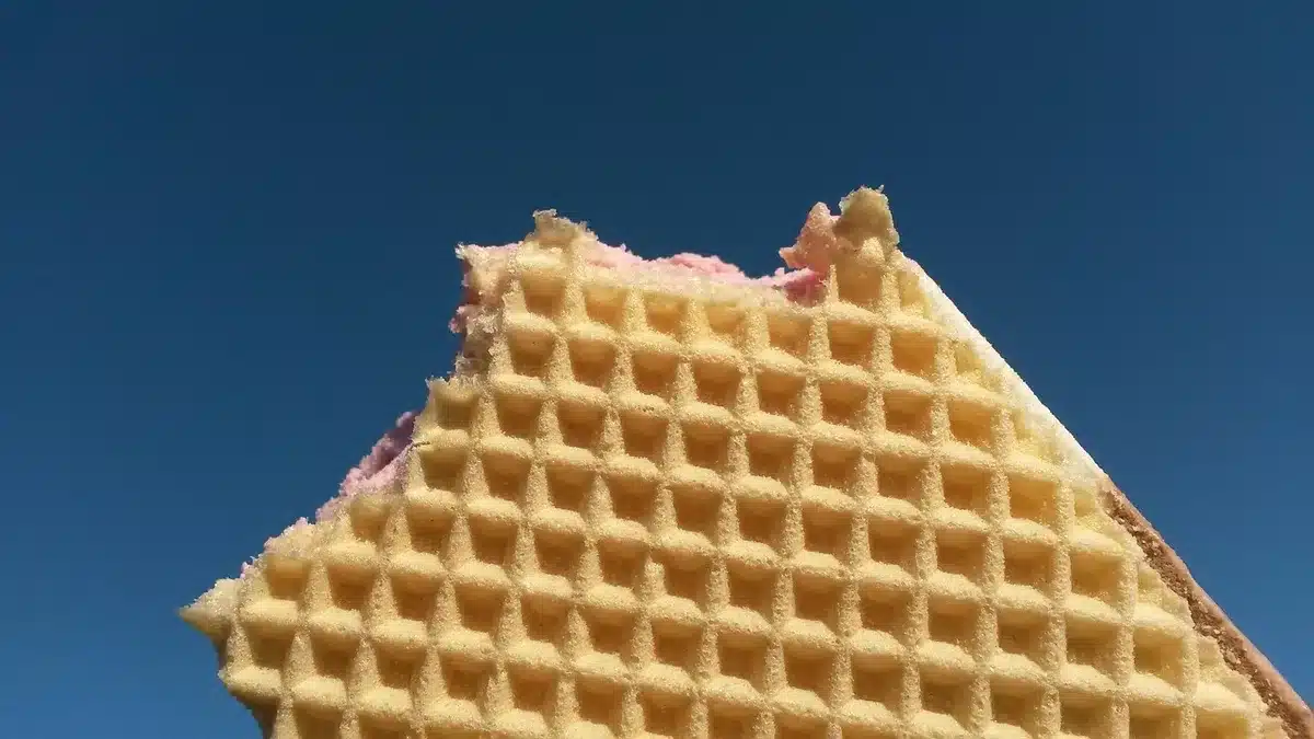 Close shot of an anonymous cleanroom entrance with a generic wafer box on a cart and empty corridor beyond, no logos or people visible